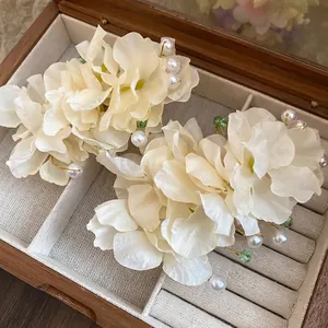 Barrettes à fleurs en tissu élégantes avec perles dans une boîte à bijoux en bois.