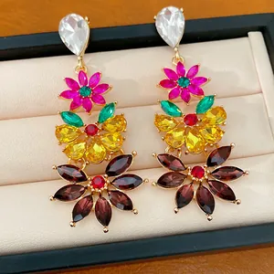 Detailed close-up of colorful vintage-style floral drop earrings with multi-colored stones