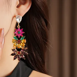 Close-up of vintage multi-colored floral drop earrings with crystals on a model.