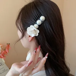 Close-up of a French style hair clip with white fabric flower and pearls