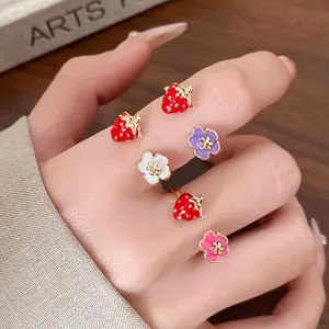 Detailed view of colorful drip oil strawberry and flower enamel open rings on hand