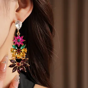 Detailed close-up of vintage multi-colored crystal floral drop earrings worn by model
