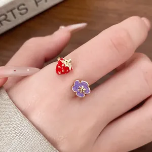 Detailed close-up showing a cute strawberry and purple flower enamel open ring worn on a finger