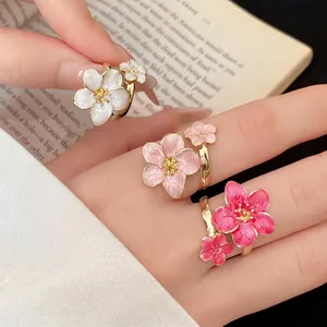 Elegant retro oil-dripping metal flower adjustable rings in white and pink shades.