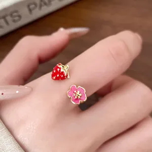 Detailed macro shot of a cute red enamel strawberry and pink flower adjustable ring