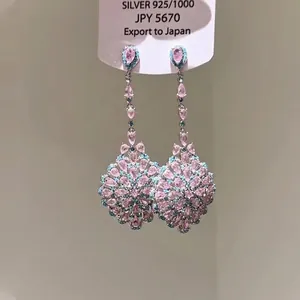 Vue macro de boucles d'oreilles vintage en argent avec pierres roses et bleues