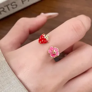 Detailed view of an elegant open ring featuring a red strawberry and pink flower motif
