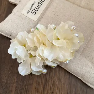 Gros plan d'une pince à cheveux élégante en fleur de tissu avec perles et perles vertes
