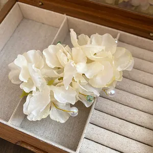 Gros plan d'une pince à cheveux élégante en tissu blanc avec perles et perles