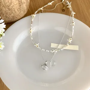 Détail d'un collier à plusieurs rangs avec pendentifs étoile de mer et coquillage