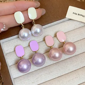 Detailed macro shot of French style enamel pearl drop earrings in three elegant colors