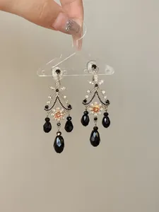 Detailed macro view of ethnic style chandelier earrings featuring black faceted glass beads