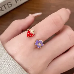 Detailed close-up view of an enamel strawberry and purple flower adjustable open ring