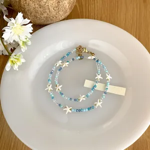 Vue détaillée d'un collier en cristal avec étoiles de mer bleu océan et blanc.