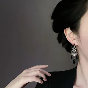 Vintage black beaded chandelier earrings with silver needle shown on model profile