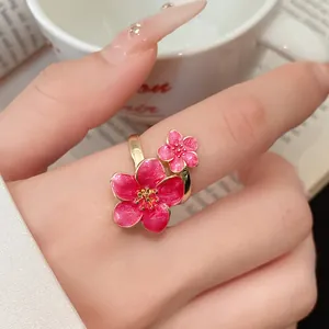 Close-up of a pink enamel flower adjustable ring with golden vintage accents.