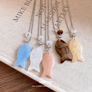 Cinq colliers avec pendentif poisson en résine de couleurs pastel sur chaînes argentées
