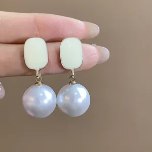 Detailed close-up view of French enamel square earrings with elegant large pearl drops