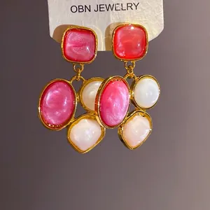 Französische Vintage-Ohrringe mit geometrischem Harzdekor in Pink und Weiß vergoldet.