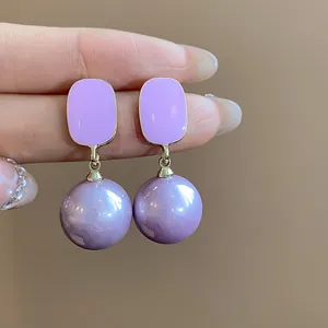 Detailed view of French style purple enamel square stud earrings with pearl drop