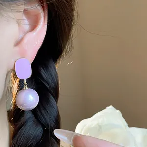 Close-up of elegant lavender rectangular enamel drop earrings with a pearl