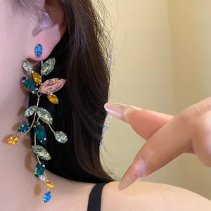 Detailed view of elegant colorful marquise stone tassel earrings on an Asian model.