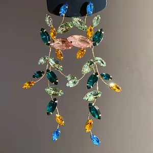 Close-up of colorful marquise-cut crystal tassel earrings with elegant gold-tone finish.