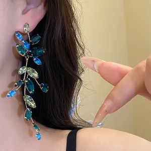 Detail of blue rhinestone leaf tassel earrings showing crystal shine and delicate craft