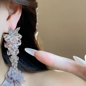 Close-up detail showing silver tassel earrings with sparkling faceted glass bead flower design