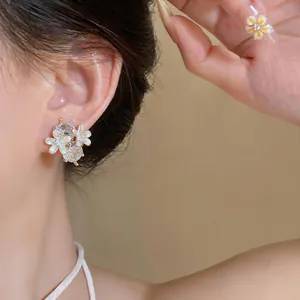 Gedetailleerde opname van elegante bloemknopoorbellen met kristallen aan een modeloor