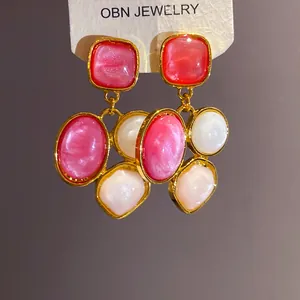 Nahaufnahme von vintage-französischen geometrischen Harzohrringen in Rosa und Weiß