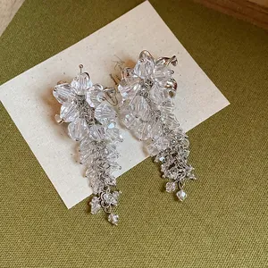 Detail view of flower tassel earrings crafted with clear glass beads and silver needle