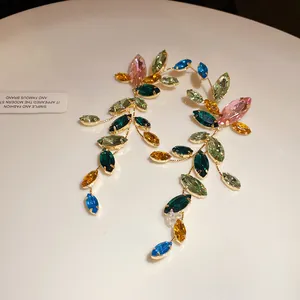 Macro view of colorful marquise-cut crystal tassel earrings in gold-tone setting