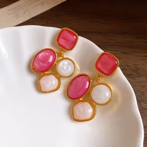 Französische Vintage-Ohrhänger aus rosa Harz mit Goldfinish auf weißer Keramik