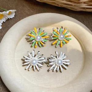 Detailed view of floral stud earrings with pearls and crystals on a ceramic plate