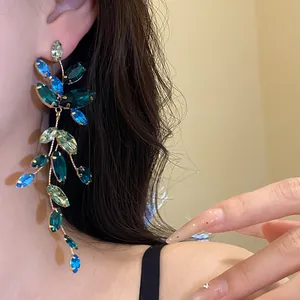 Detailed view of elegant dangling earrings featuring blue and green marquise crystals.