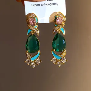 Detailansicht von luxuriösen Ohrhängern mit grünem Zirkonia und blauer Emaille