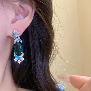 Detailansicht eines eleganten smaragdgrünen Tropfenohrrings mit Zirkon und blauem Emaille