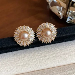 Exquisite close-up of vintage pearl stud earrings featuring a sparkling sunburst zircon halo