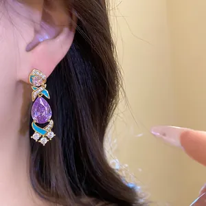 Nahaufnahme eleganter violetter Zirkonia-Ohrringe mit blauer Emaille an einem asiatischen Model