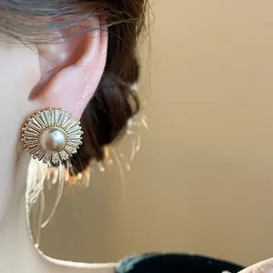 Detailed close-up showing the elegant vintage zircon sunburst pearl stud earring on model's ear