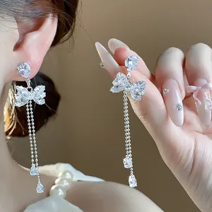 Close-up detail of silver butterfly earrings with sparkling zircon tassels
