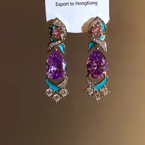 Nahaufnahme eleganter violetter Zirkon-Ohrringe mit türkisfarbenen Emaille-Akzenten