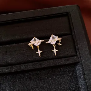 Vue macro détaillée de boucles d'oreilles vintage dorées avec pierre carrée et breloque étoile