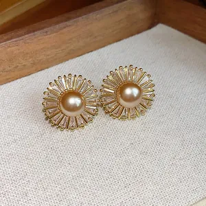 Detailed close-up of vintage pearl and zircon sunburst stud earrings with gold finish