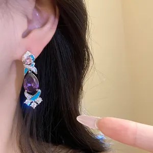 Nahaufnahme von eleganten lila Tropfenohrringen mit Emaille- und Zirkoniadetails