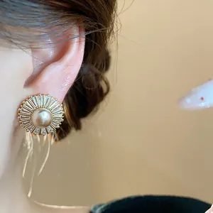 Macro view of a French vintage zircon and pearl earring with delicate gold chain tassels