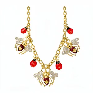 Vintage gold-toned necklace featuring detailed bee and ladybug charms with crystal wings
