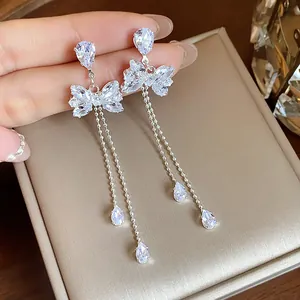 Sparkling butterfly tassel earrings with silver needles and zircons on jewelry box