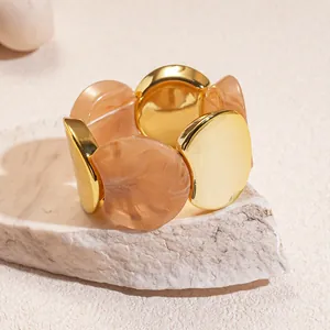 Macro close-up of a retro acrylic and gold metal round elastic bracelet for women
